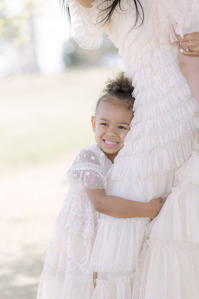 Girl hugging mom in the park at their family session | Adrienne Elizabeth Photography